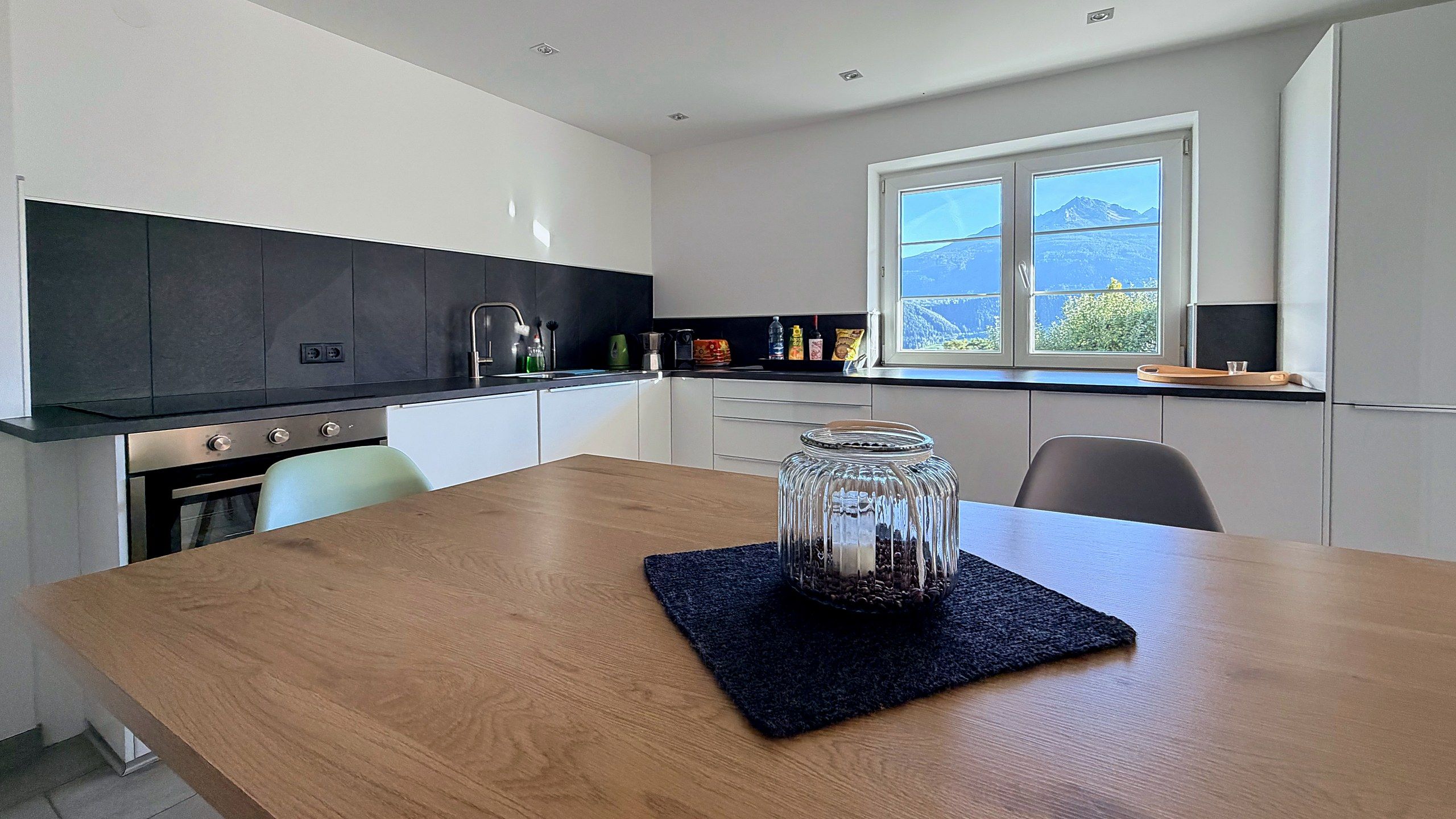 Esstisch in der Küche, durchs Fenster Blick auf die Berge